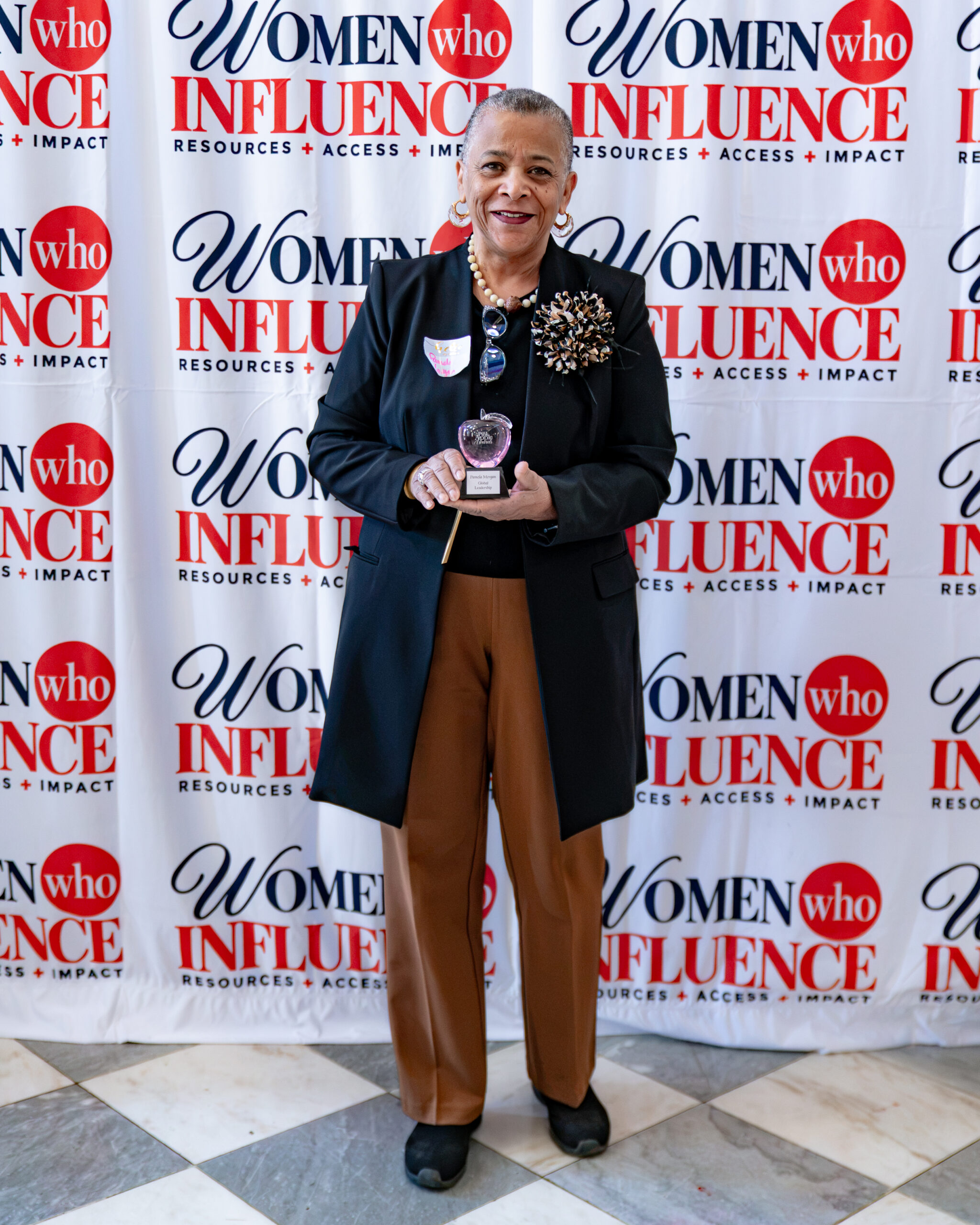 Pamela Morgan holding her Crystal Apple Award for Global Leadership