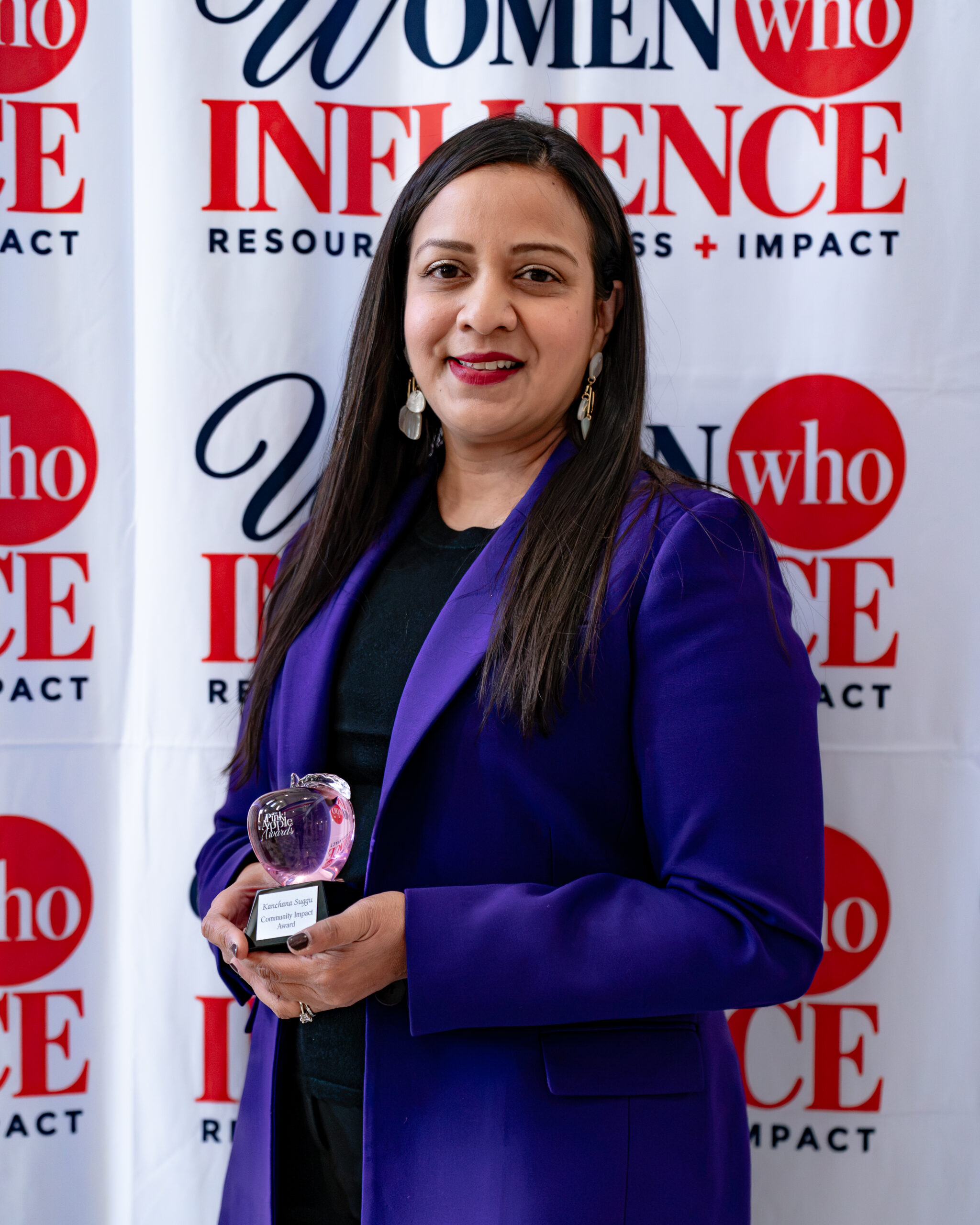 Kanchana Suggu holding her Crystal Apple Award for Community Impact