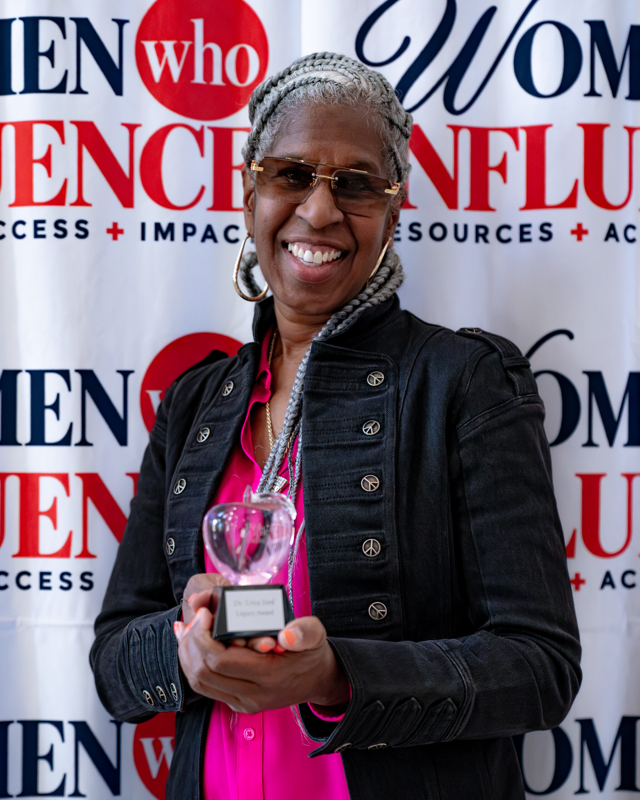 Dr. Erica Ford holding her Crystal Apple Legacy Award